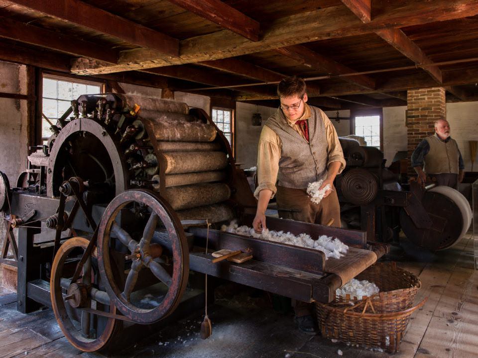 A costumed historian works the Carding Mill