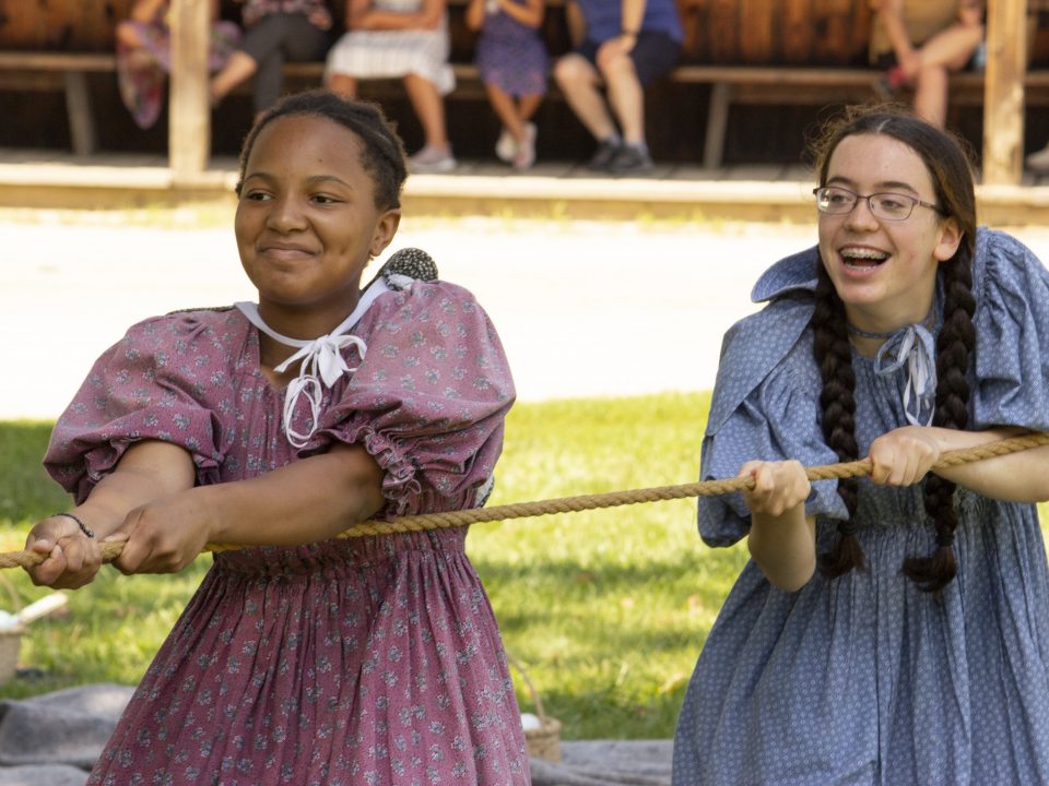 Two girls play tug of war