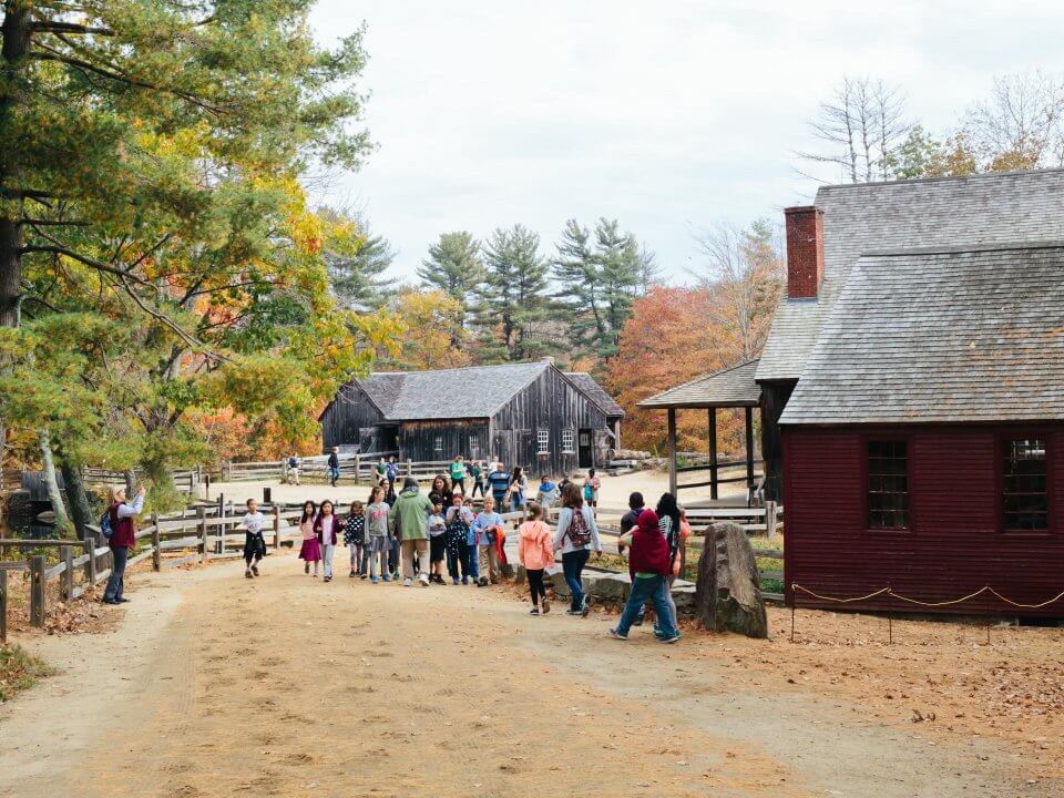 A group of students exploring three water-powered mills