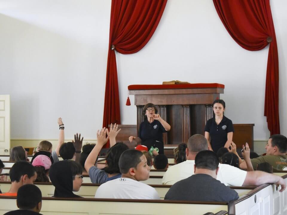 Kids sitting in the Center Meetinghouse for a discussion