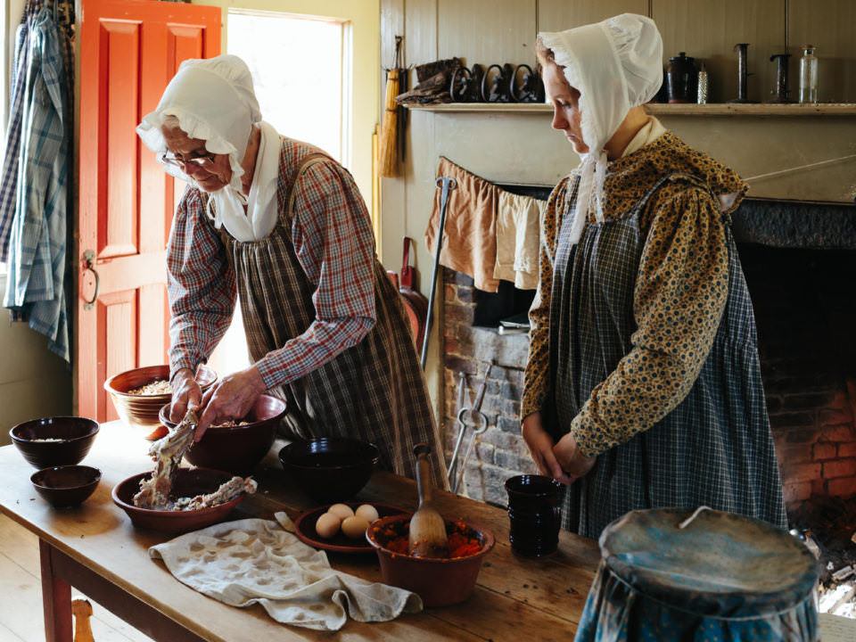 2 costumed historians cooking in the Freeman Kitchen