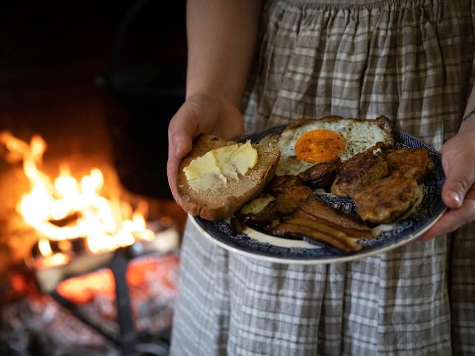 A plate with hearth-cooked breakfast foots like eggs, bacon, and toast