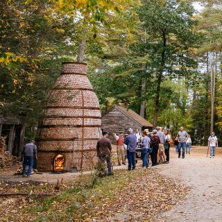 people gathered around a 24 ft tall brick kiln