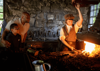 Blacksmith at work with visitors watching demonstration